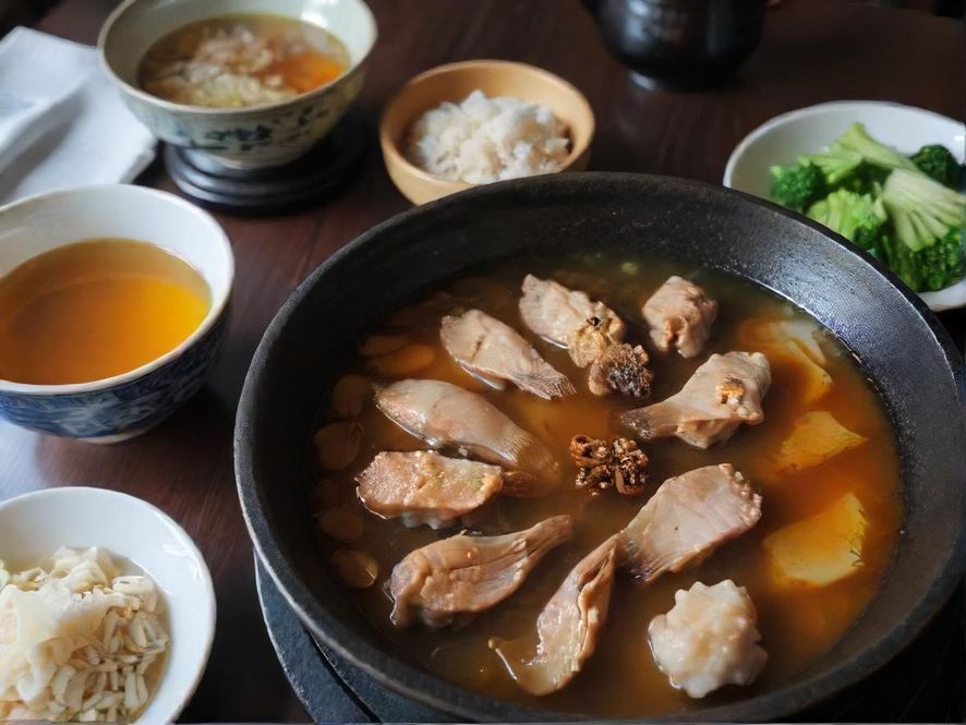 广州一家热闹餐厅里摆满了各种特色美食，食物色泽诱人，餐具精致，充满烟火气。
